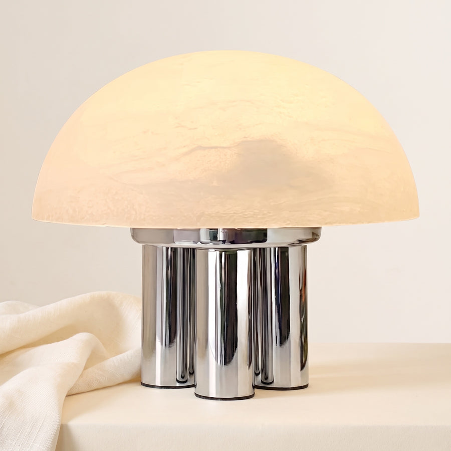 Iris dome table lamp, lit, on chrome columns, off-white tabletop with linen drape