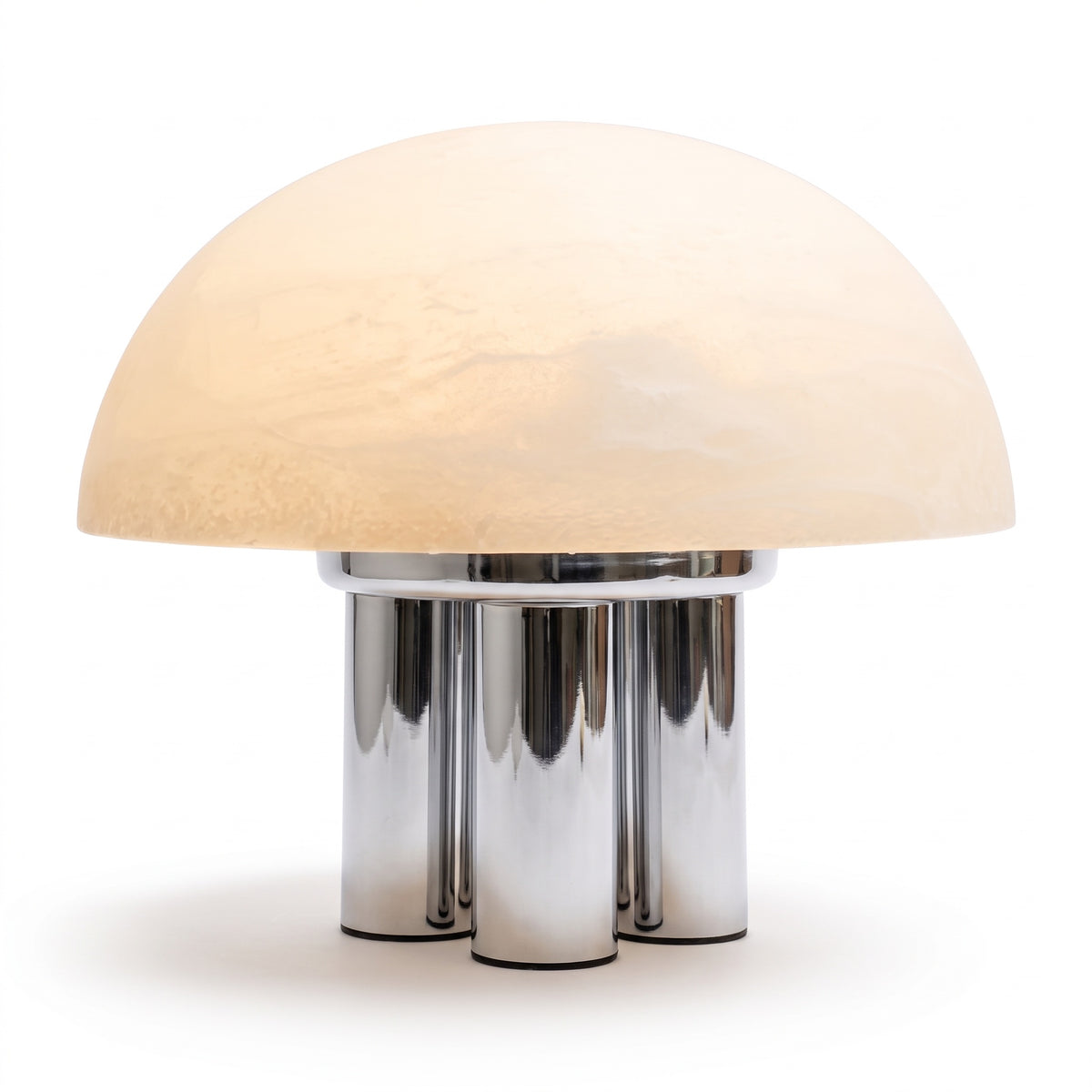 Iris dome table lamp, lit, on chrome columns against a white background