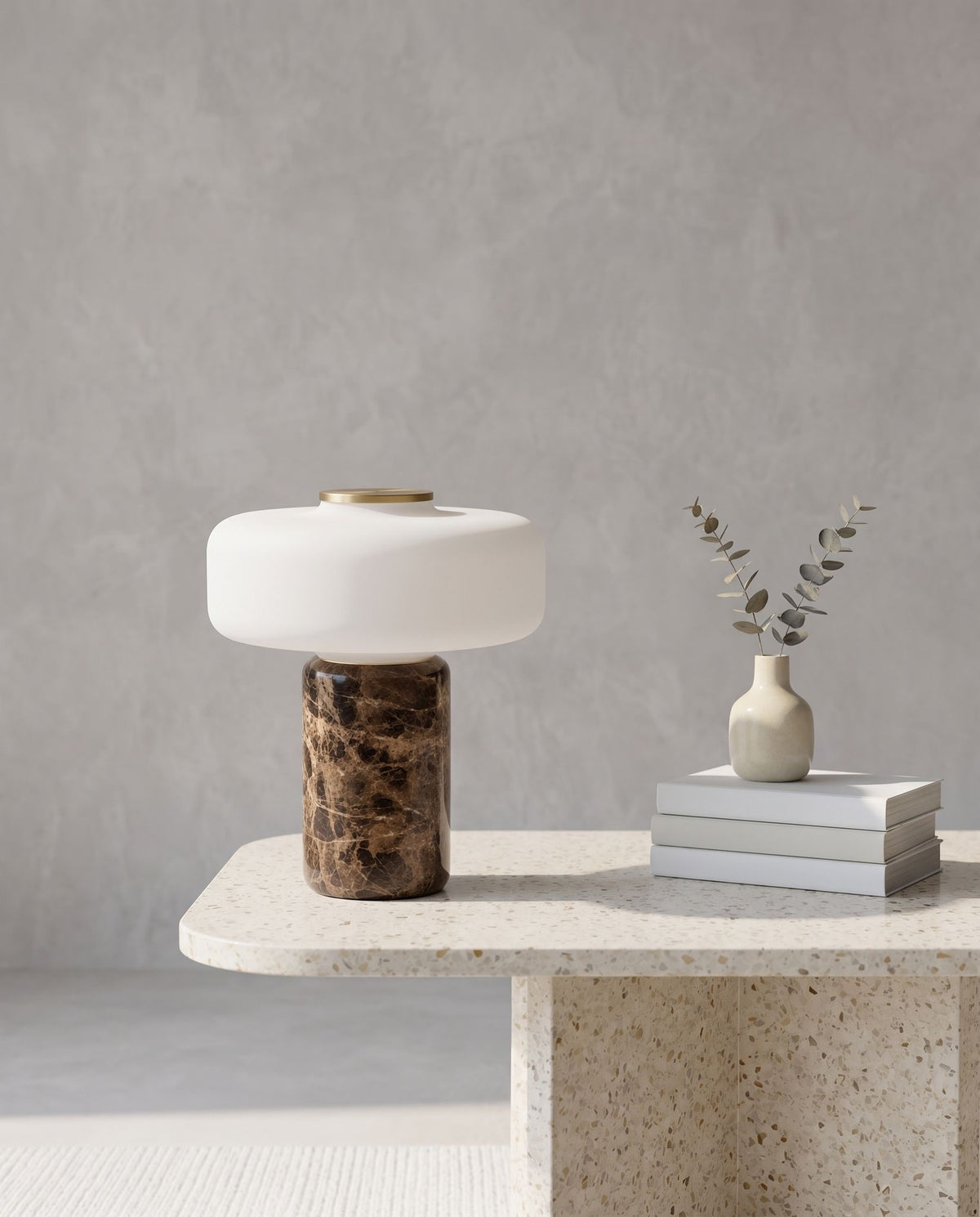 Lysa marble and glass table lamp on a terrazzo table with books, vase and plaster wall