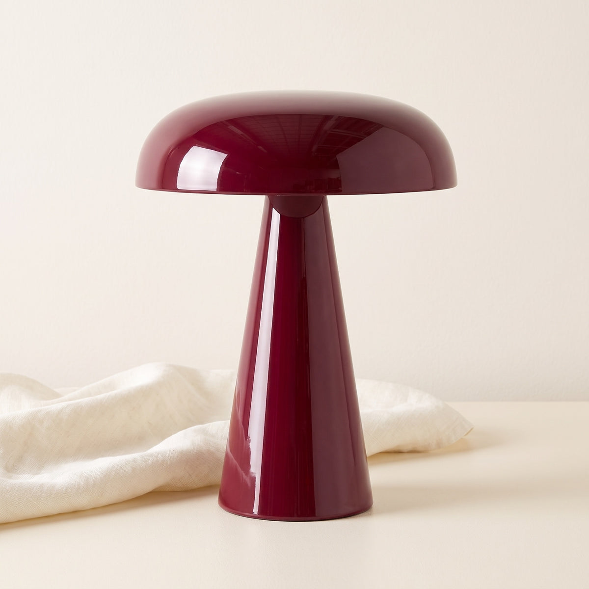 Rubra lacquered table lamp on a cream backdrop with linen cloth