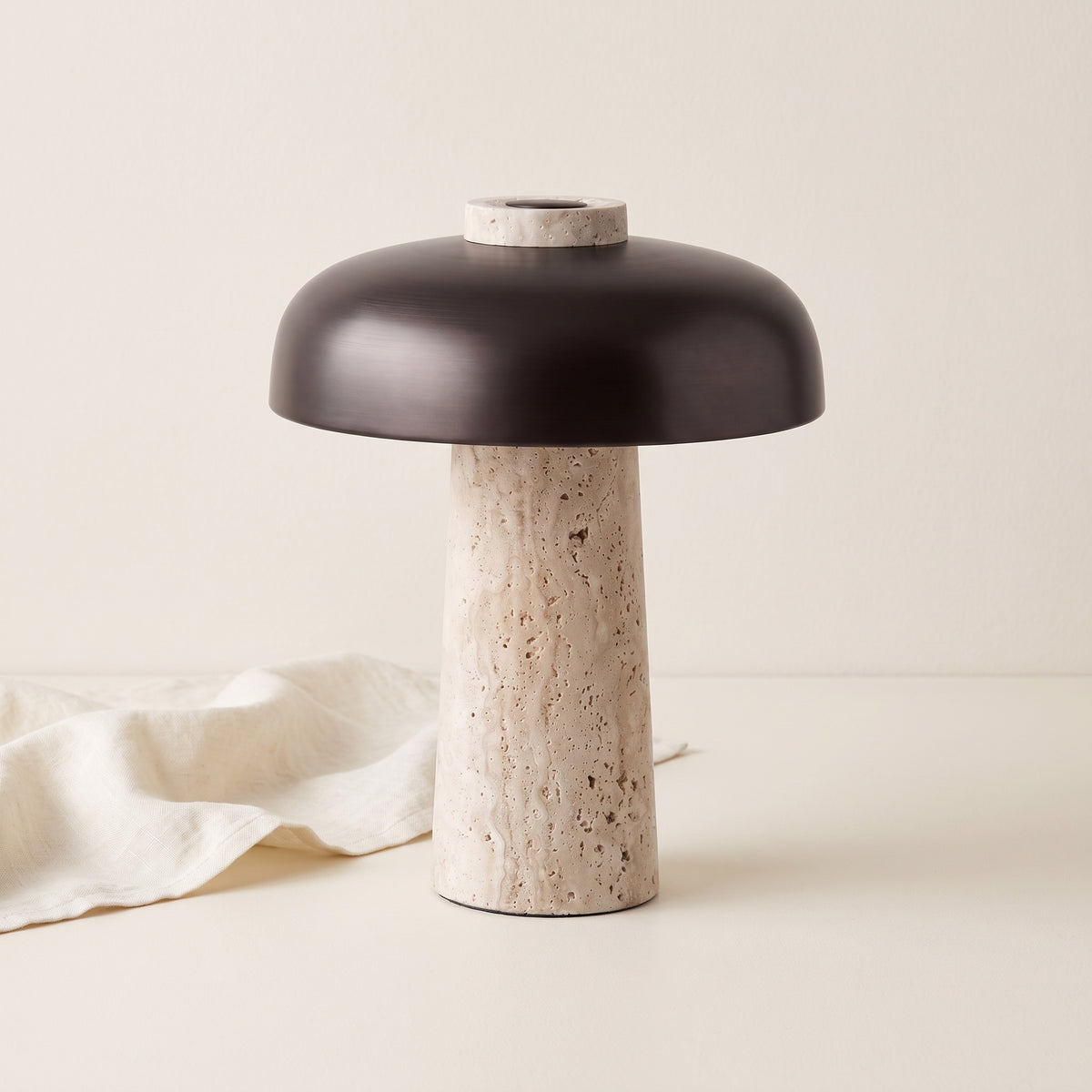 Silex rechargeable travertine table lamp on a cream backdrop with linen cloth