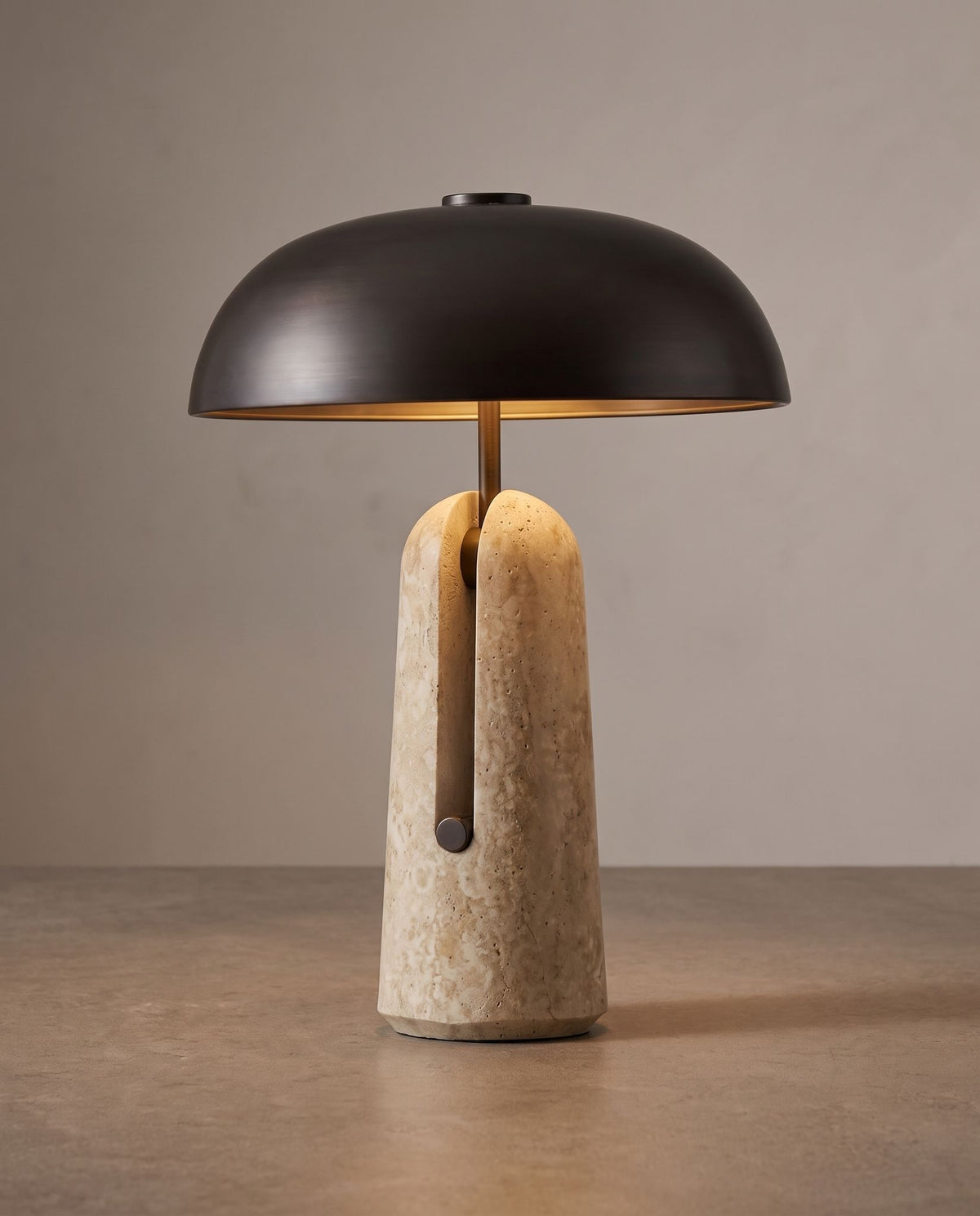 Sillon travertine and iron table lamp on a taupe surface against a greige backdrop